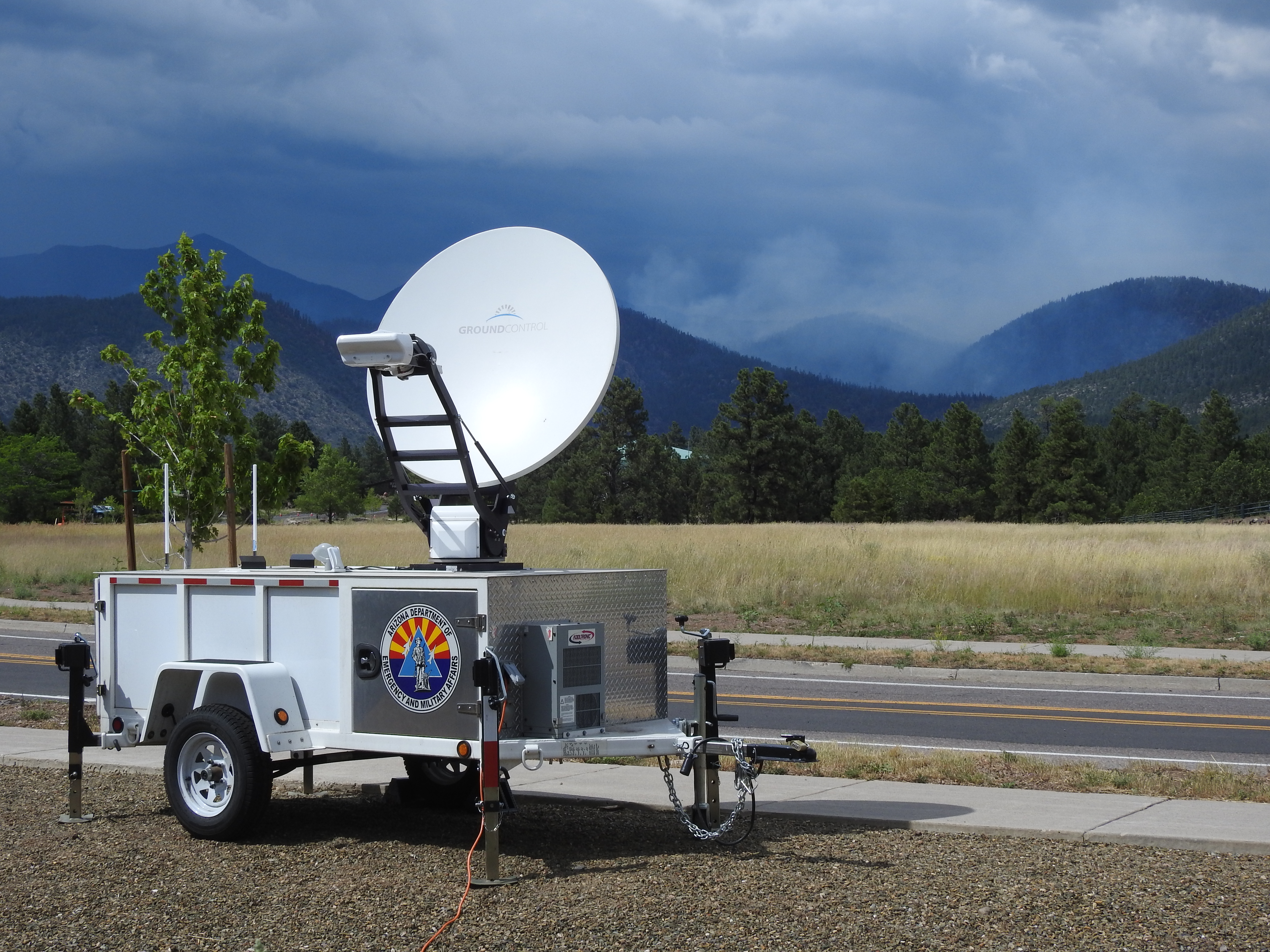 Photo of the Statewide Interoperable Communications also known as the "Jackrabbit",   parked pn the side of the road near the wildfire across the mountains.