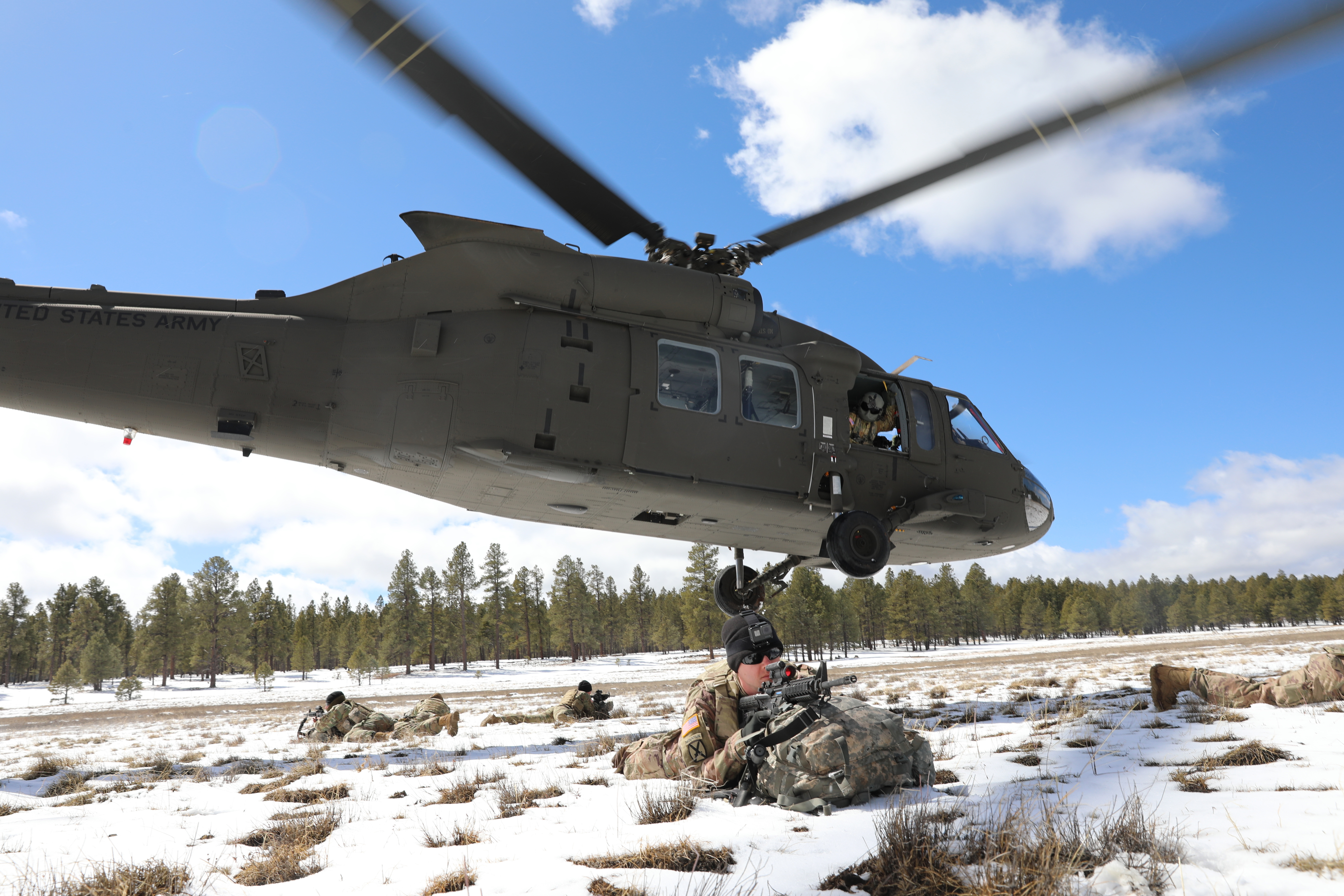 Soldiers pull security, as a UH-60 Blackhawk helicopter lifts off after completing an air assault drop at Camp Navajo.