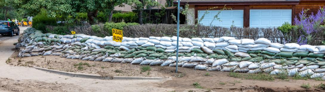 Photo of a corner house in Flagstaff with stack of sandbags around it's property, getting ready for the forcasted flooding.