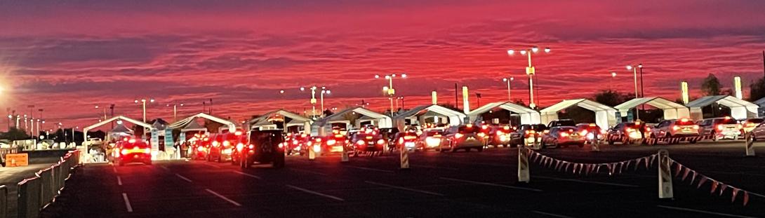 Photo of the PODs at the State Farm  Stadium parking lot at sundown. Cars lined up on each lanes to get vaccinated. This was taken during the COVID-19 outburst in 2020-2021.