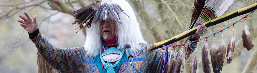 Native American dressed up in traditional clothes giving out Awards