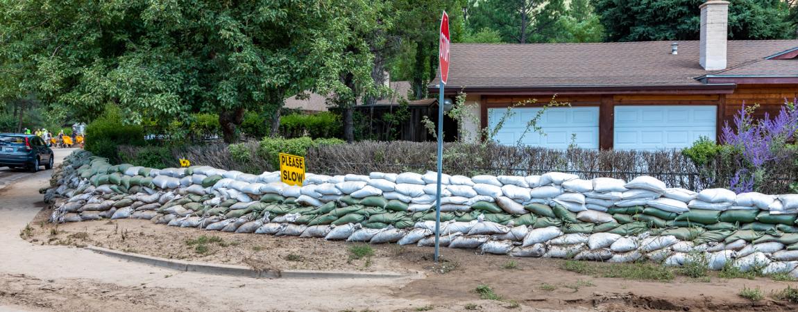 Photo of a corner house in Flagstaff with stack of sandbags around it's property, getting ready for the forcasted flooding.