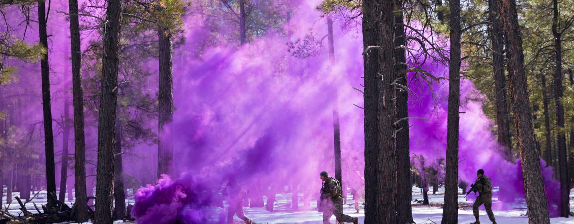 Soldiers employ a smoke grenade to conceal their movement as they prepare to capture a high value target during an urban terrain event in Camp Navajo.