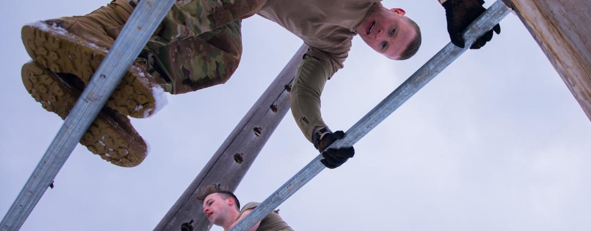 Soldiers bound over the A frame of the obstacle course at Camp Navajo.